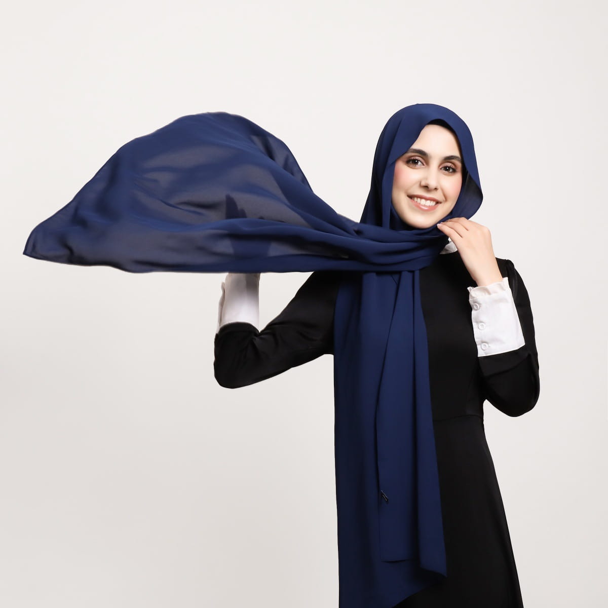 Un hijab en mousseline magnétique bleu marine, confectionné dans un tissu léger et transparent qui s’écoule avec délicatesse.