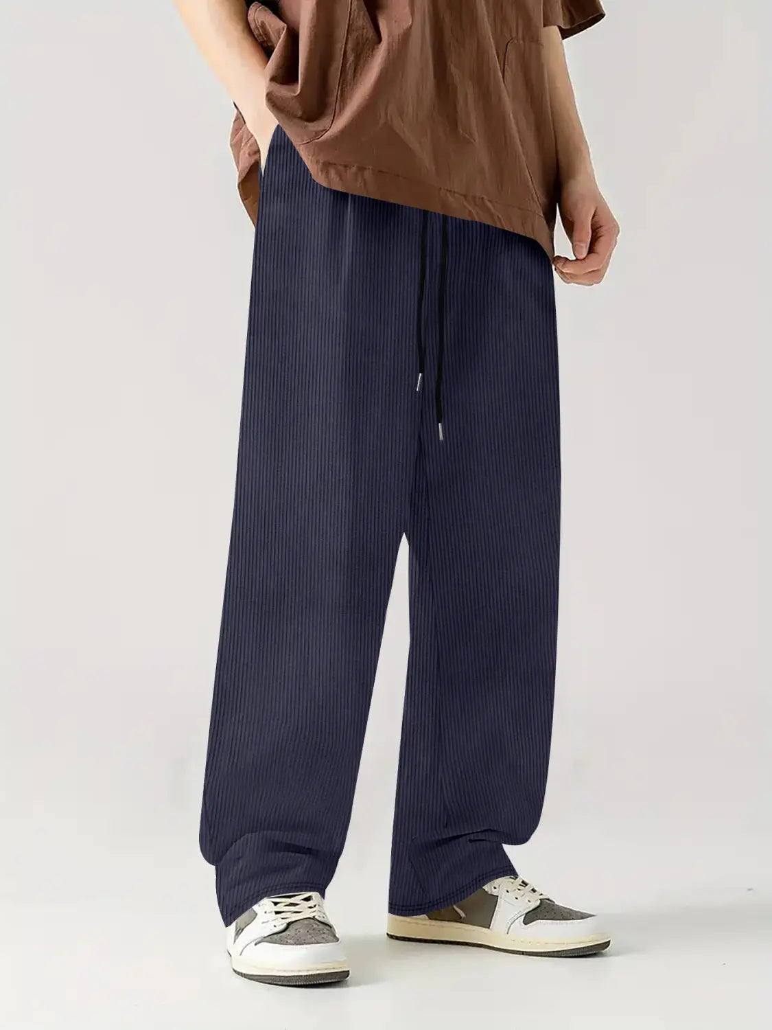 Pantalones casuales rectos de pana azul marino oscuro con cordón, textura acanalada vertical y cinturilla elástica.