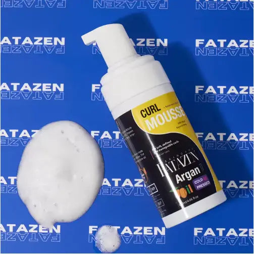 White plastic bottle of fatazen argan curl mousse with yellow and black label and pump dispenser designed as argan oil curl mousse strong hold hair styling foam.