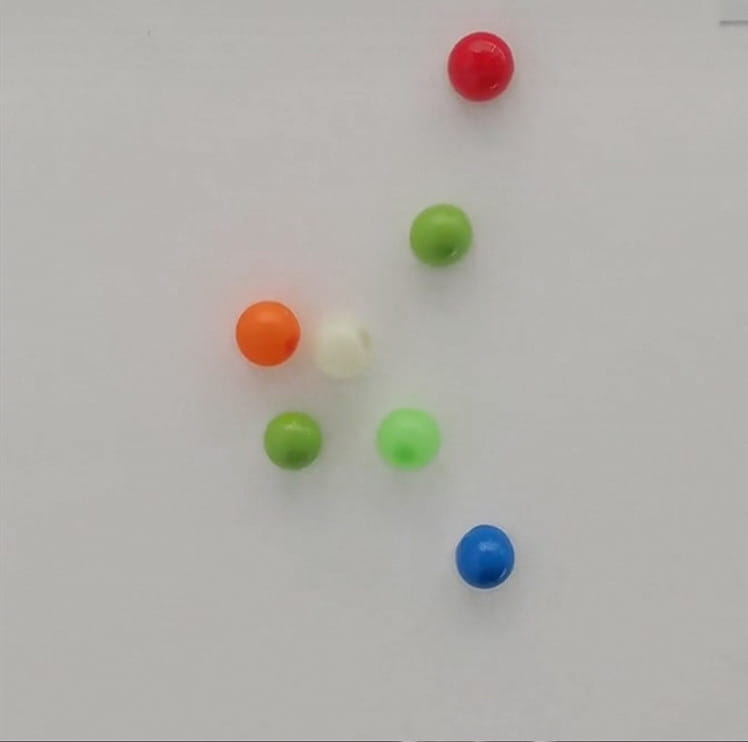 a collection of colorful glossy plastic beads in red orange green blue and white for sticky wall ball stress relief glow squash toys
