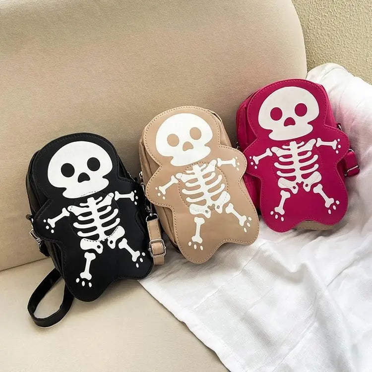 Three black beige and pink y2k skeleton skull crossbody bags feature white skeletal designs on a shoulder strap for casual use.