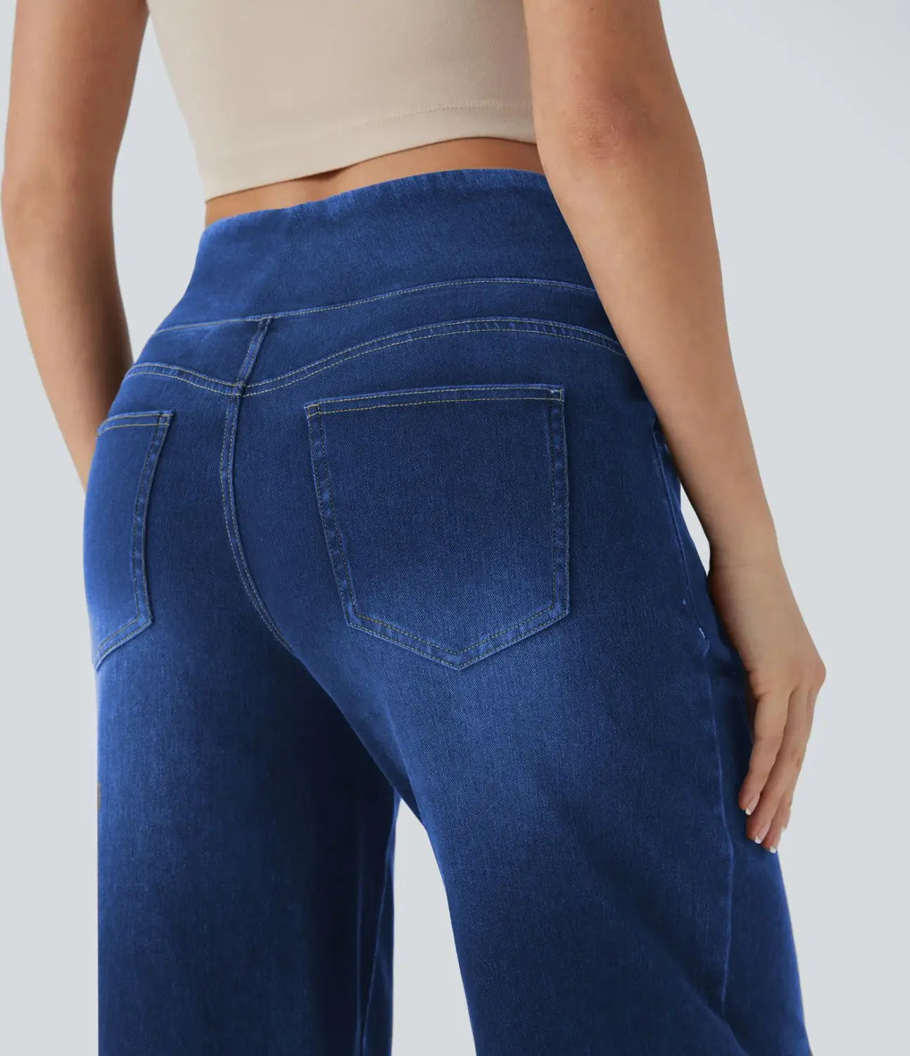 Wide leg stretchy high waisted jeans in blue denim with a comfortable stretchy waistband and classic back pockets shown from the back side.