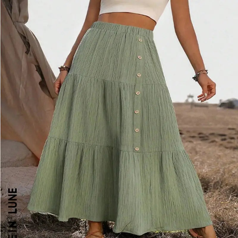 A flowing sage green tiered maxi skirt with a gathered waist and button closures designed for lightweight casual wear.