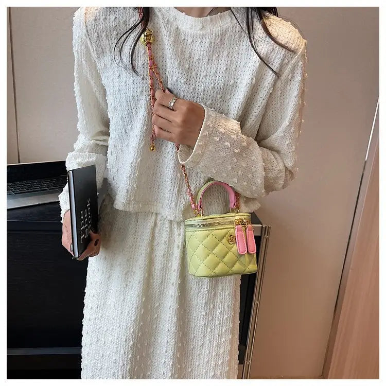 Pastel green quilted diamond chain crossbody bag with pink handles and gold-tone hardware made of pu leather.