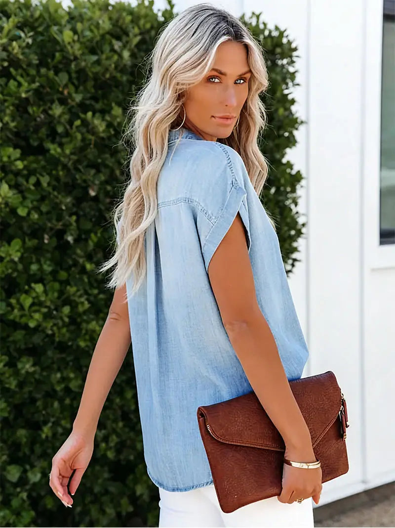 bolso de mano tipo clutch de cuero marrón con textura combinado con camisa de manga corta de mezclilla color azul claro, mostrado sobre un fondo blanco
