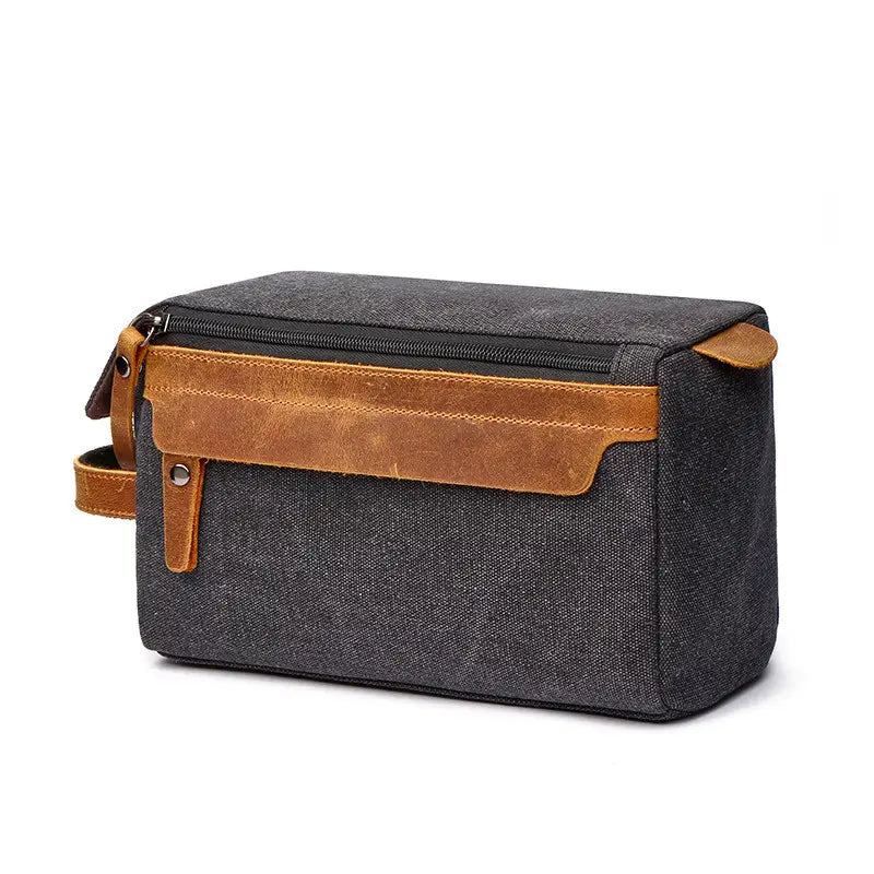 dark gray canvas toiletry bag with tan leather accents and zipper closure for large portable travel storage case