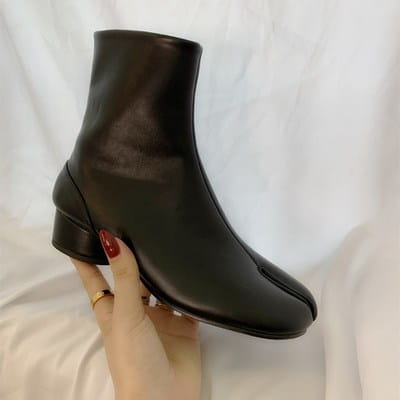 Black leather ankle boot with a low block heel and distinctive split toe seam shown from the back side.