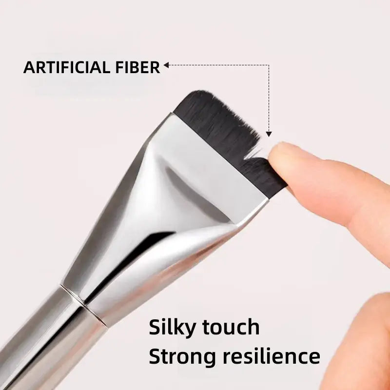 Silver metallic ultra thin foundation brush with flat traceless design and black artificial fiber bristles for precise makeup application.