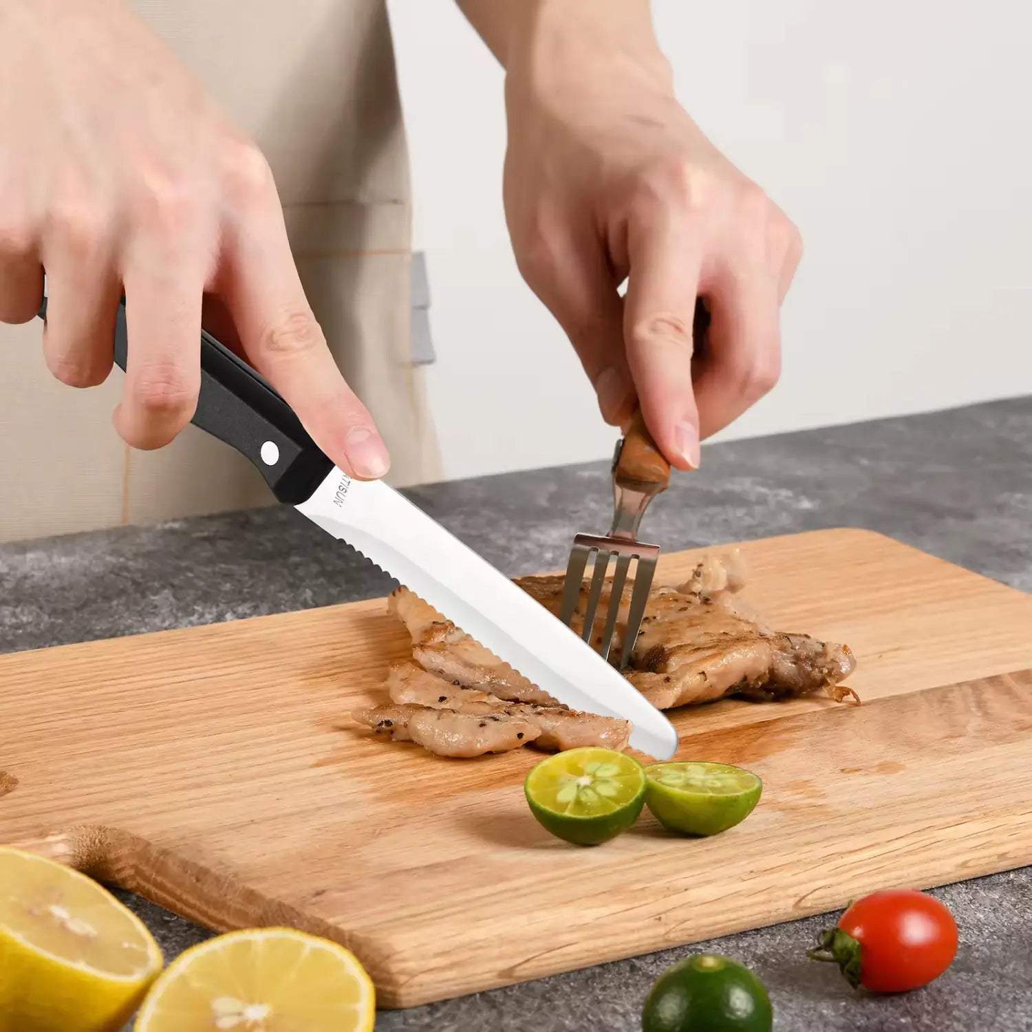 Cuchillo dentado con mango negro y hoja de acero al carbono de acero inoxidable, para cortar carne sobre una tabla de cortar de madera, de un set de 12 piezas de cuchillos de cocina con mangos de ABS.