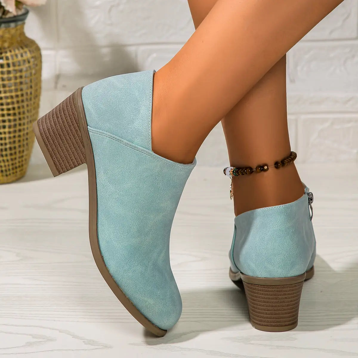 Light blue suede ankle boot with a textured brown chunky block heel and side zipper closure.