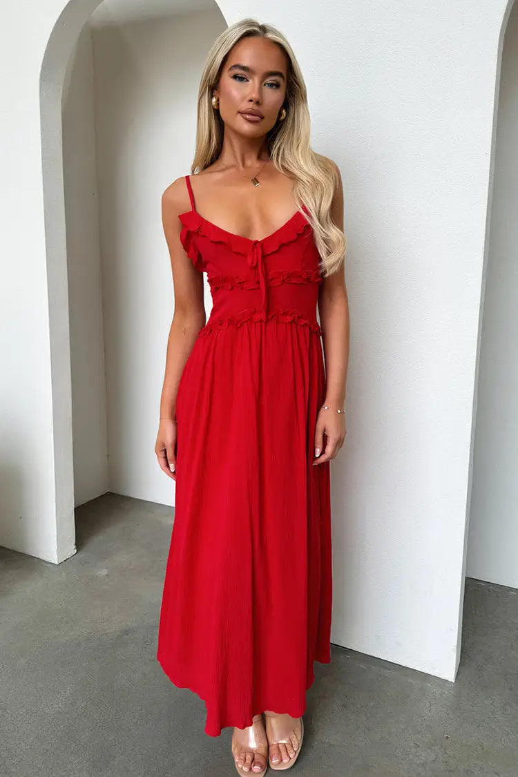A vibrant red flowing maxi vacation dress with delicate ruffled sleeveless straps and a fitted bodice.