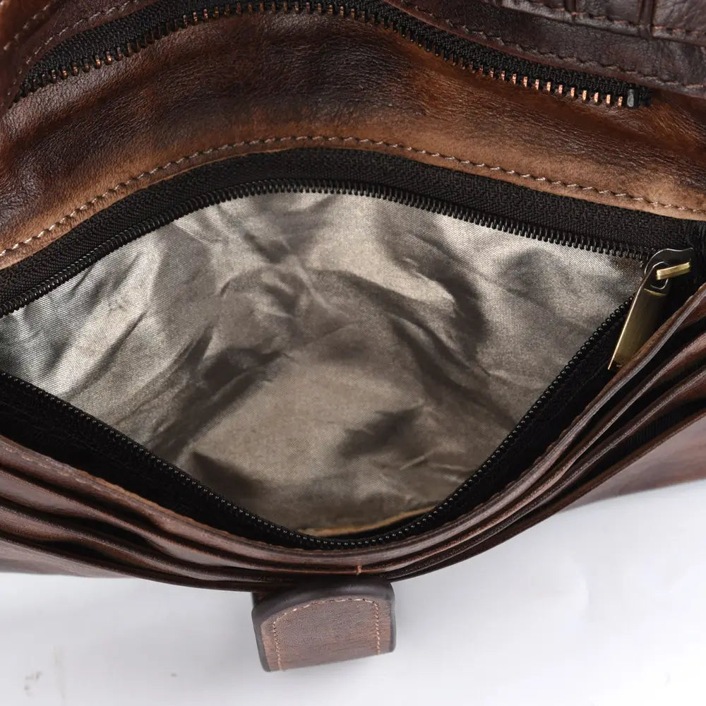 Brown leather long wallet with vintage stitching featuring a silver-toned interior lining and black zipper trim.