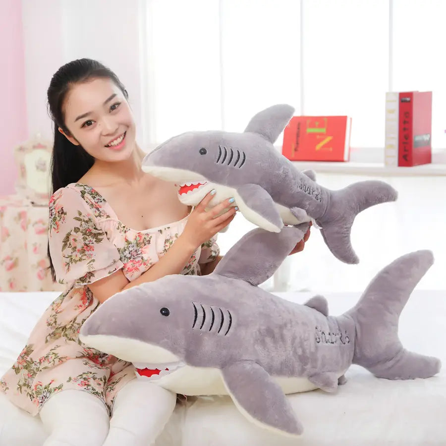 Gray plush shark stuffed toy with white underbelly featuring red stitched teeth and gills designed as a soft shark plush toy.