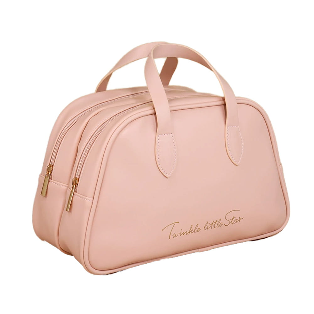 Une trousse de maquillage de voyage en similicuir rose tendre, avec des fermetures éclair et des anses de tonalité dorée, conçue comme une trousse de toilette imperméable.