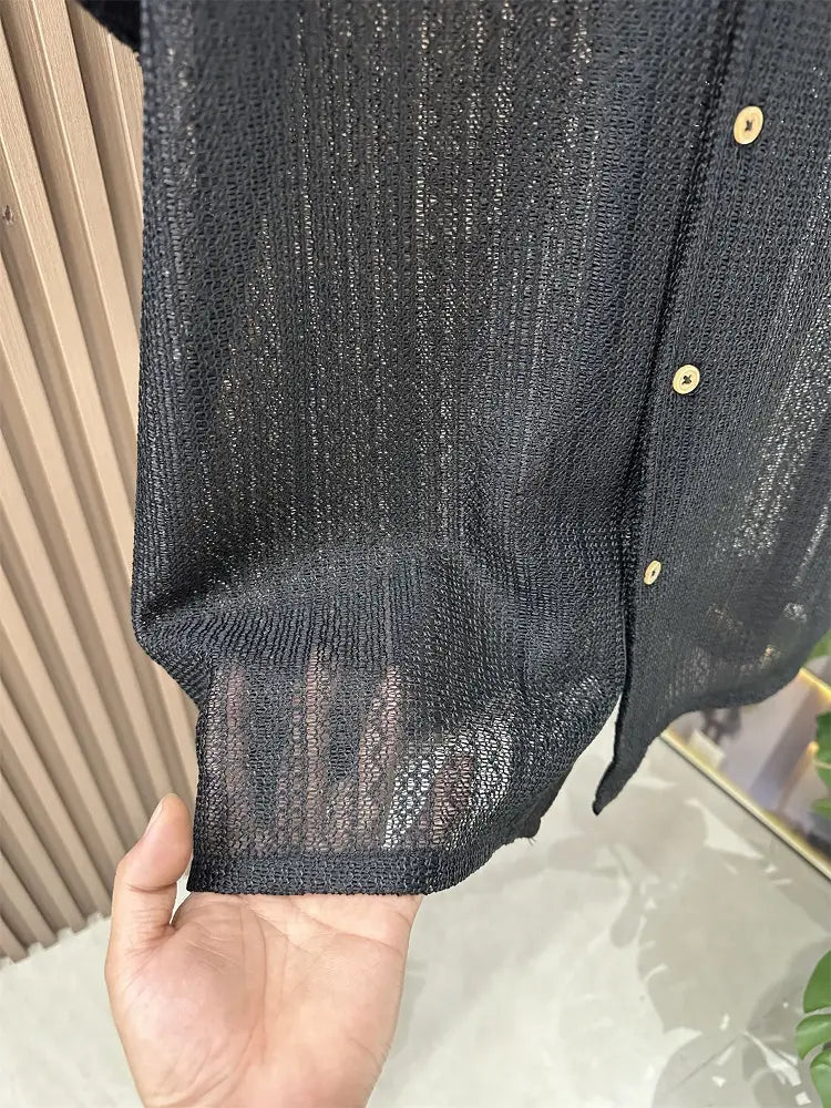 Schwarzes Herren-Strickhemd mit kurzem Ärmel in strukturierter Optik, dezentem Schimmer und goldfarben wirkenden Knöpfen für den Freizeitgebrauch.