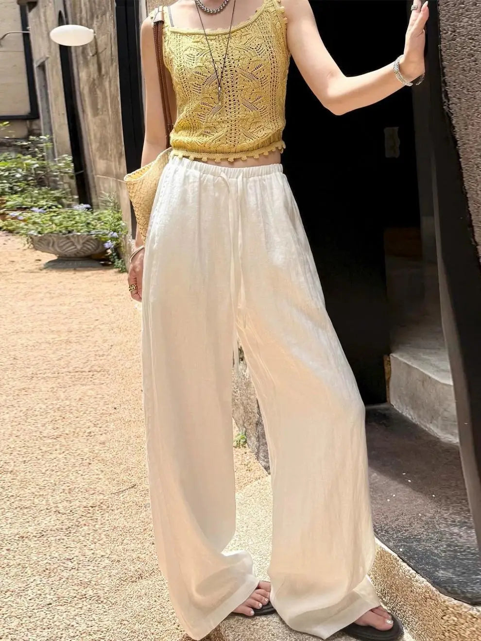Pantalon ample en lin blanc de couleur crème à taille haute avec ceinture à cordon et tissu fluide