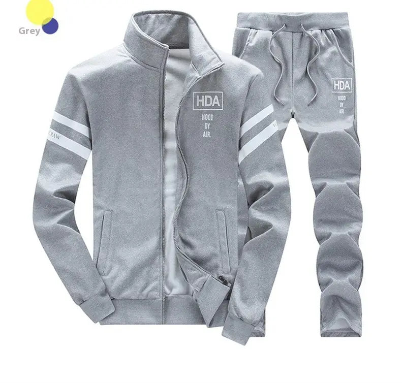Mens grey hda branded track suit athletic zip sweatshirt jacket with white stripes and lettering on the jacket sleeves front chest panel and pants leg.