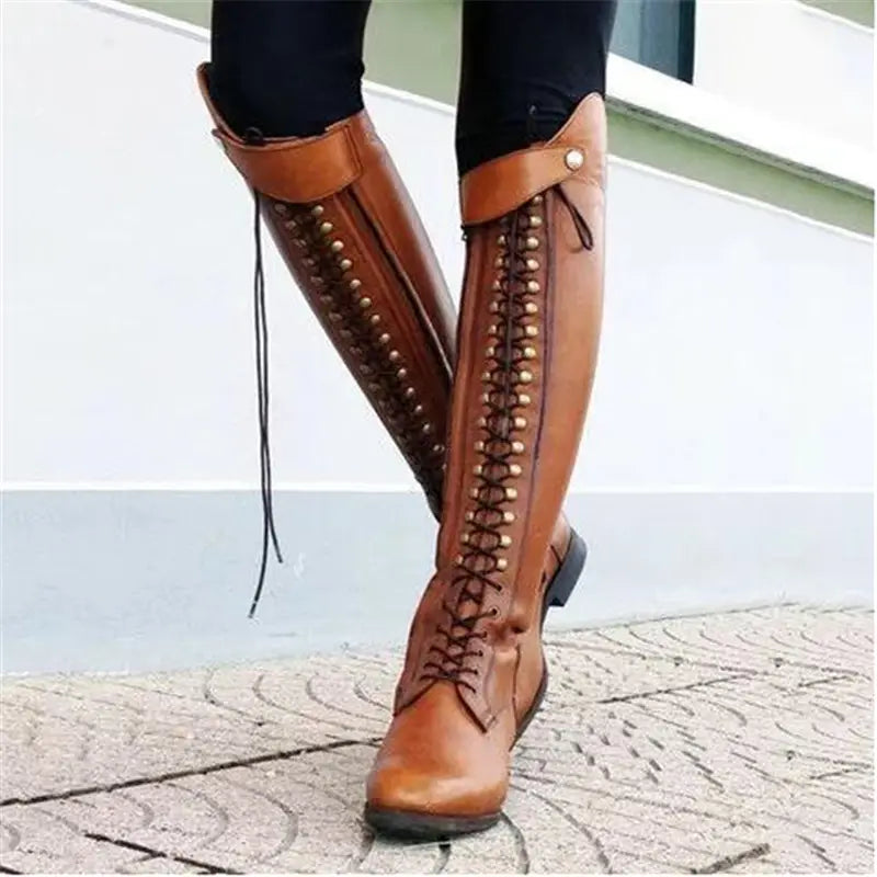 brown leather over the knee riding boots featuring decorative lacing and metallic studs