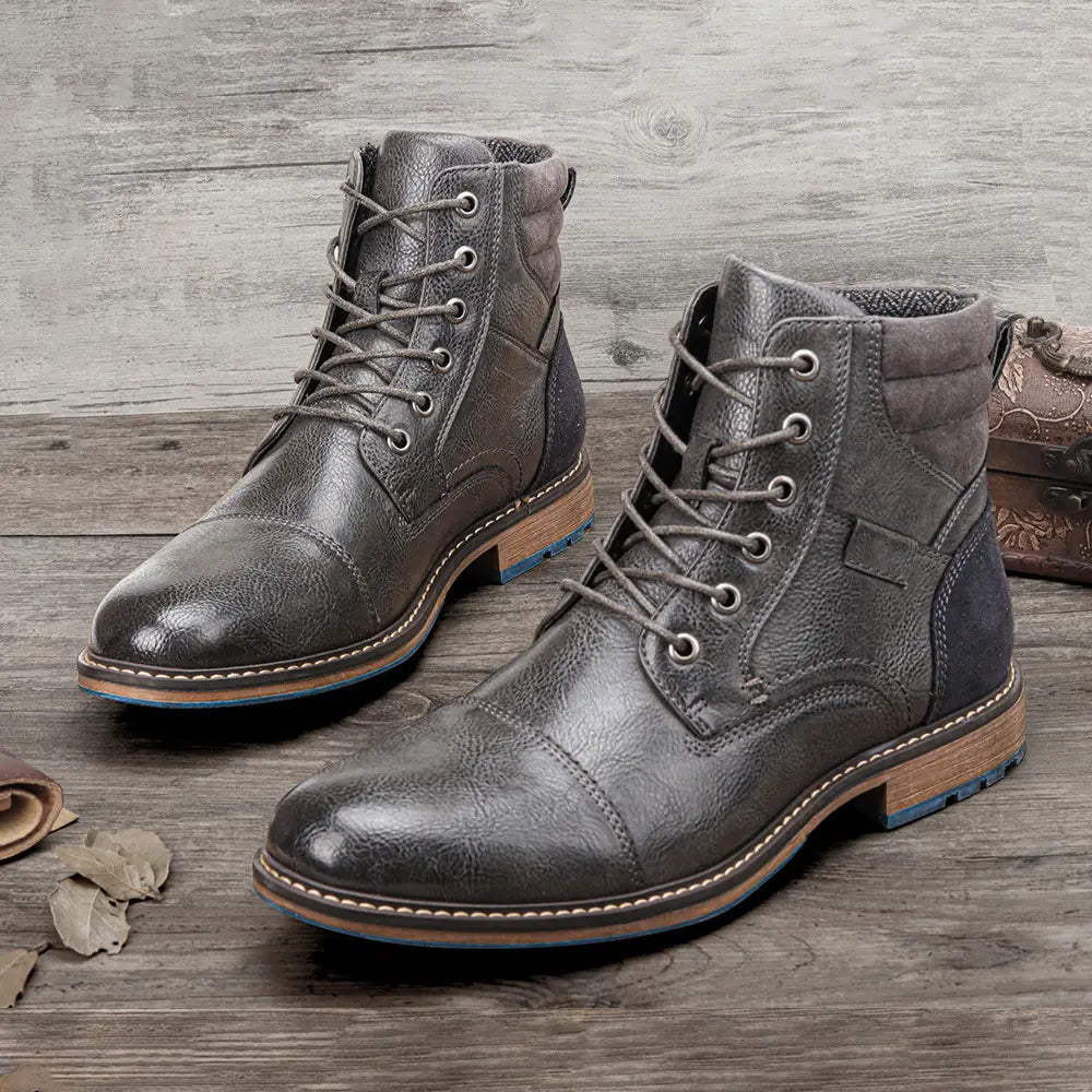 Men’s leather martin boots featuring dark gray leather with a rugged distressed finish and contrasting tan blue rubber sole.