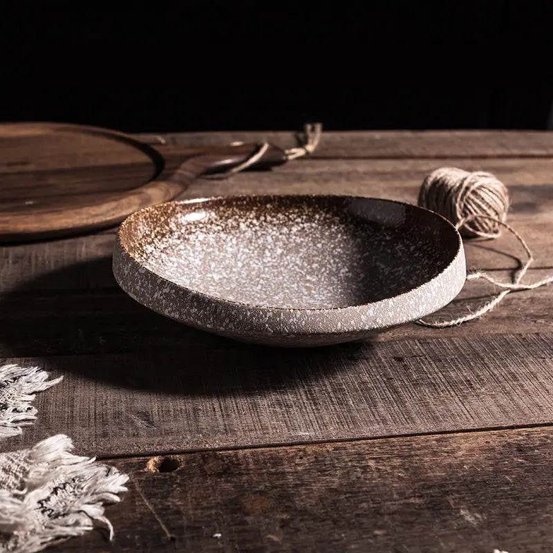 A rustic ceramic speckled serving bowl with earthy brown and gray glaze for home kitchens.