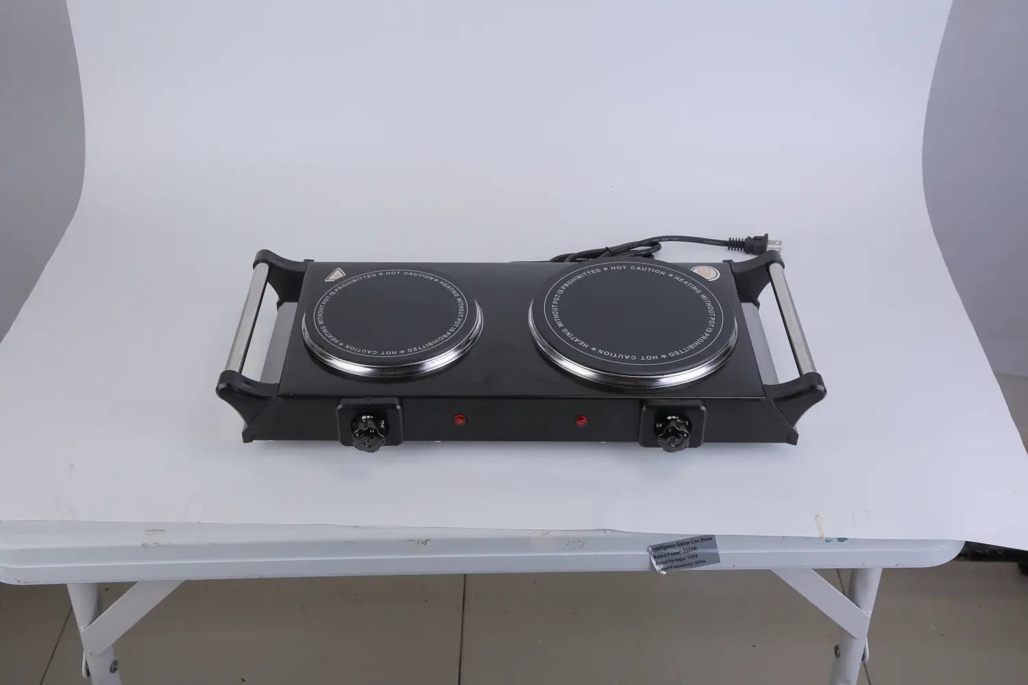 Black dual-burner electric hot plate with silver-rimmed infrared cooking surfaces and metallic side handles in a portable 1800w double burner design.