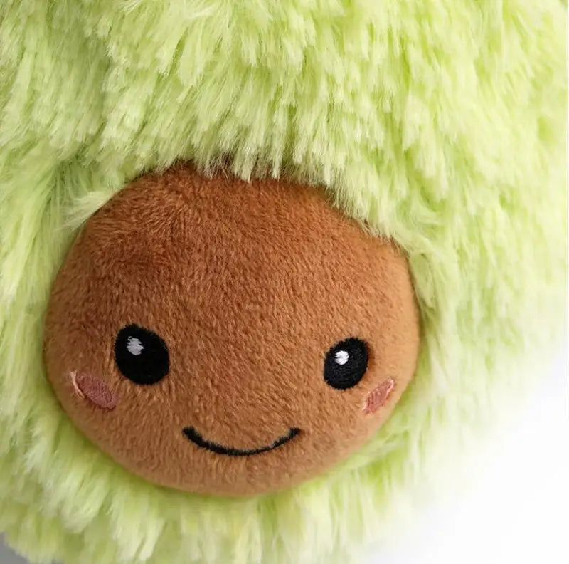 A soft light green plush avocado toy with a brown face featuring black eyes and rosy cheeks designed as a stuffed cartoon pillow.