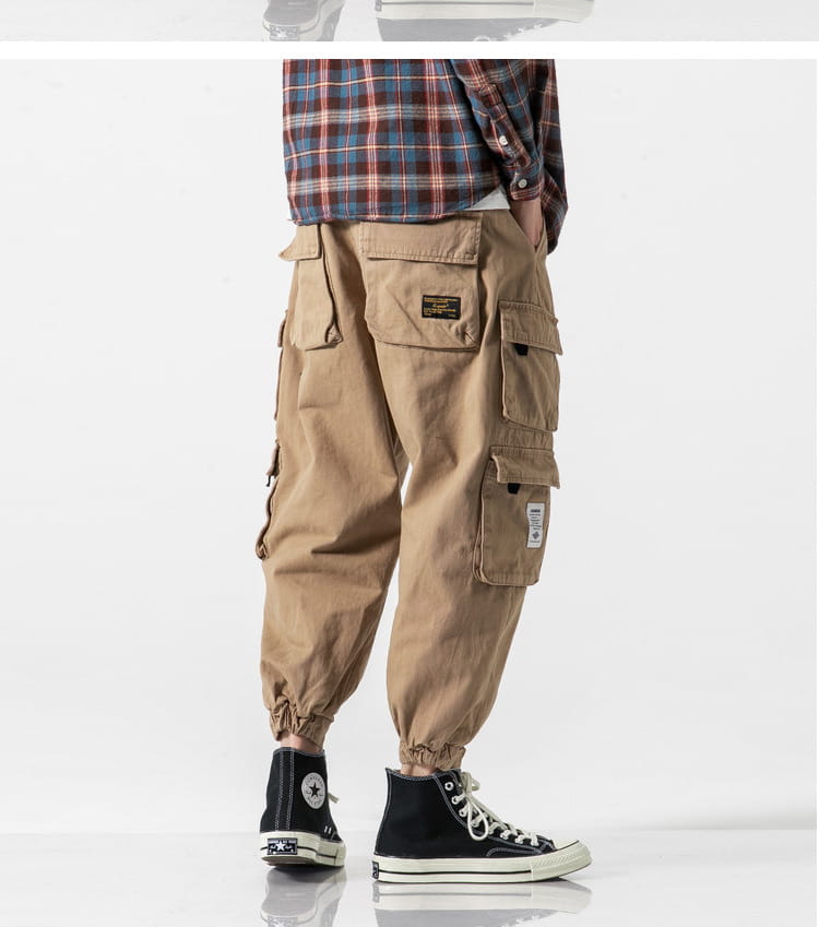 Pantalones cargo militares japoneses casuales color beige, de tiro cónico, con múltiples bolsillos y puños elásticos, diseñados para el uso cotidiano práctico.