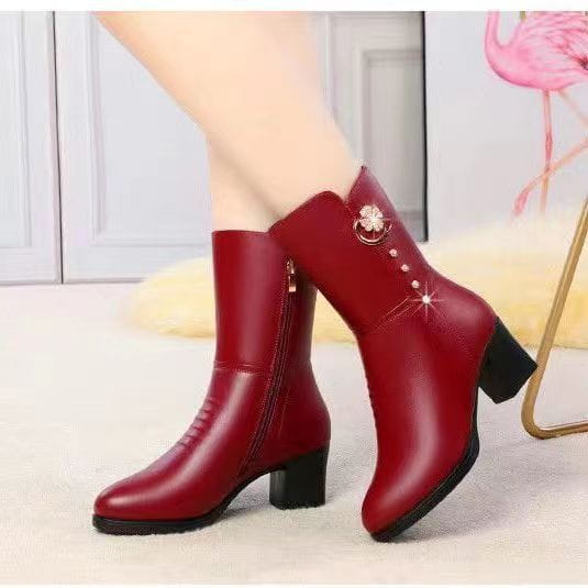 Red leather women’s martin boots featuring floral brooch embellishments and pearl-like accents.