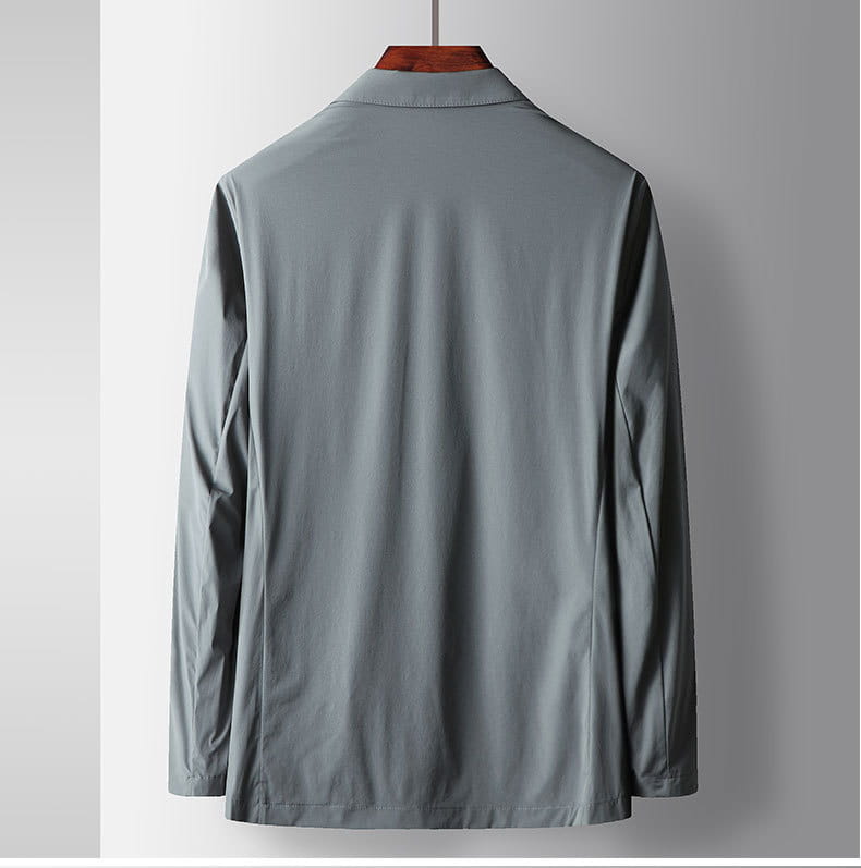 Ein elegantes, hellgraues Herren-Hemd mit langen Ärmeln, dezentem Schimmer und sauberer Verarbeitung, kombiniert mit einer leichten Stretch-Anzugjacke gegen Falten.