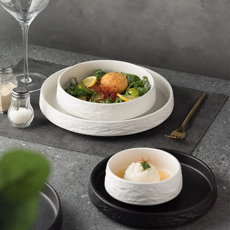 Plato hondo de piedra de cerámica blanca con patrón de piedra, superficie rústica con textura y borde ligeramente abierto para vajilla japonesa.