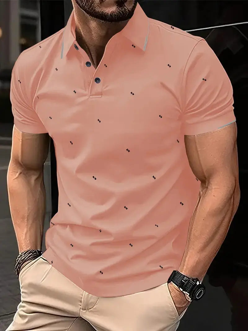 Kontrastiertes Herren-Poloshirt in Pfirsichfarbe mit dezentem schwarzem geometrischem Muster auf den kurzen Ärmeln und navyblauen Knöpfen.