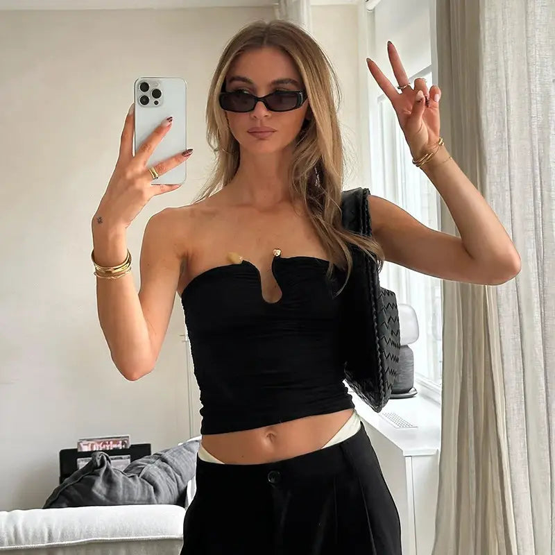 Black strapless keyhole crop top with a distinctive heart-shaped cutout at the center and gold-tone button accents.