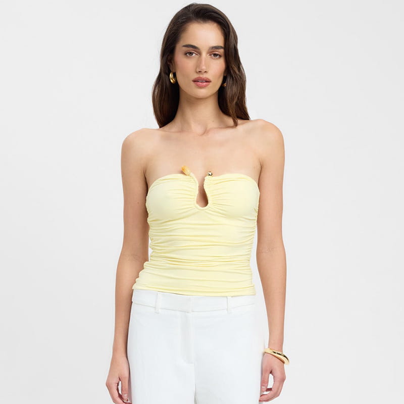 A pale yellow strapless keyhole crop top with ruched detailing and gold-tone hardware.