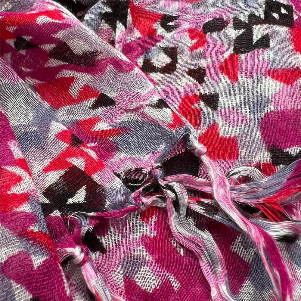 Una bufanda larga de viscosa fluida vibrante de color rosa, negro y gris con patrón geométrico y extremos con flecos para vestidos.