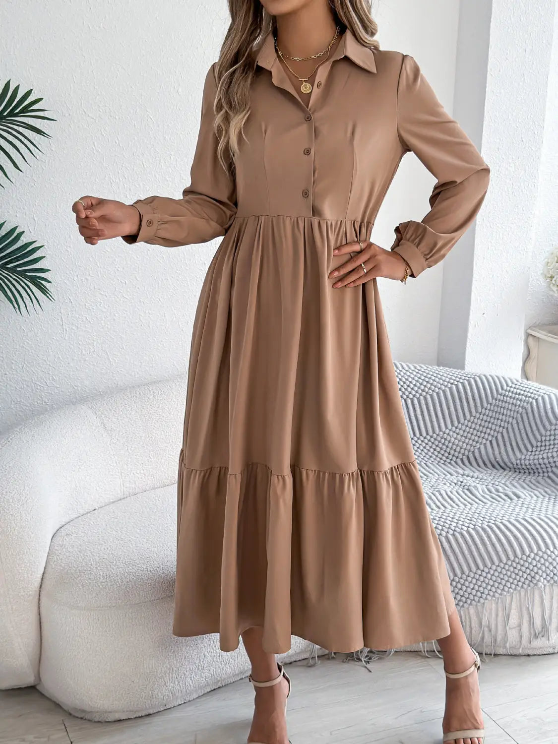 A beige long sleeve button down midi dress with a tiered skirt and collar designed for women.