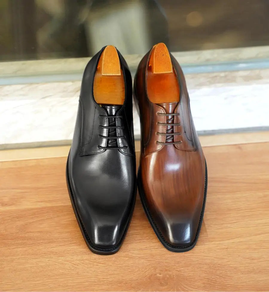 Ein Paar Herren-Oxfordschuhe mit eckiger Kappe aus beschichtet wirkendem Leder mit einem eleganten schwarzen und einem edelbraunen polierten Lederfinish.