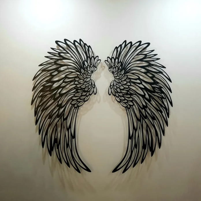 Black metal angel wing wall art featuring intricate feather detailing and integrated led lights.