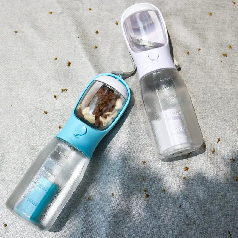 Gourde pour chien bleu et blanc avec réservoir transparent et bec intégré, présentée dans un distributeur portable 3 en 1 avec sac à crottes.