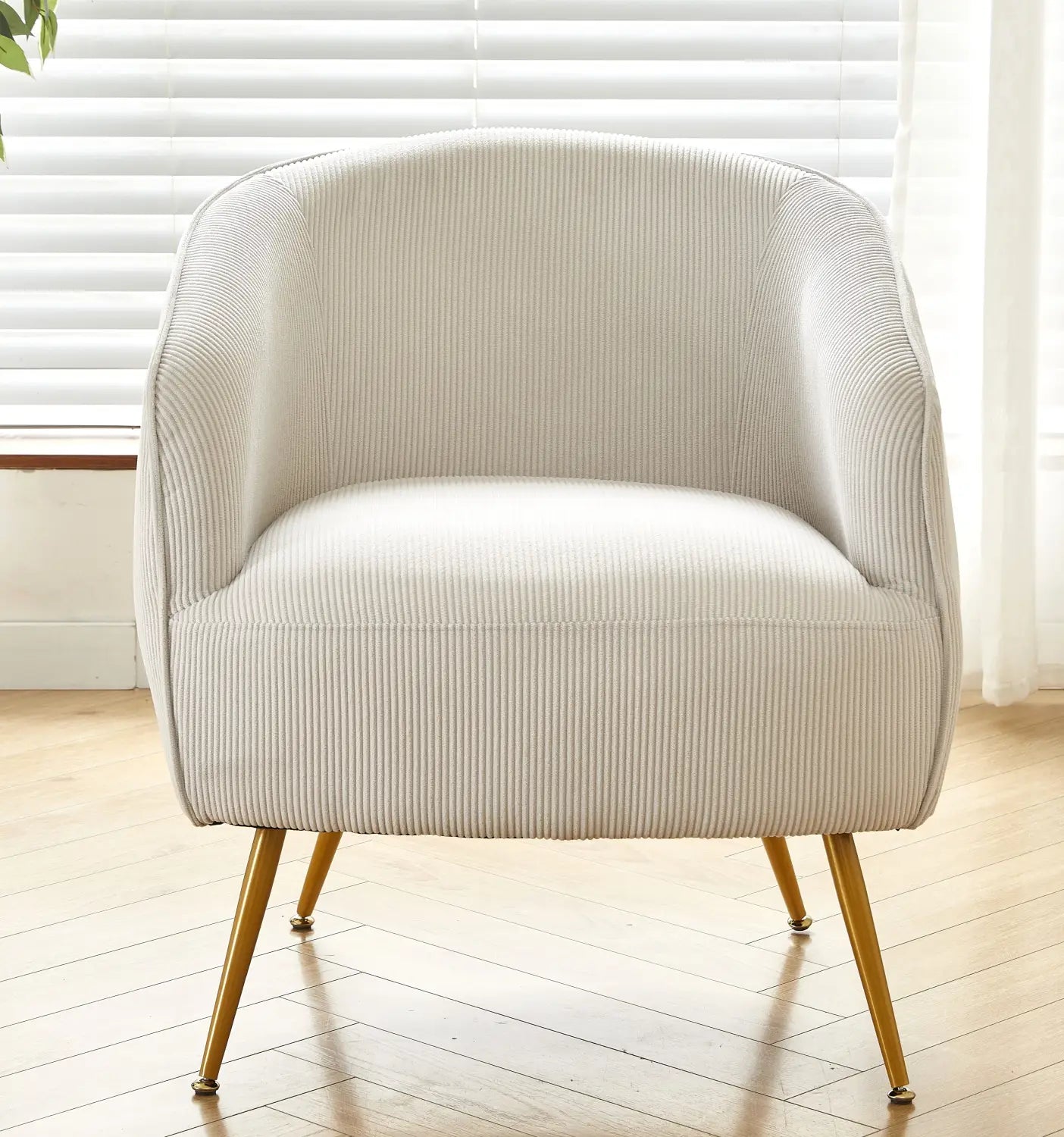 Cream-colored corduroy accent chair with gold-tone metal legs in beige shown from the front.