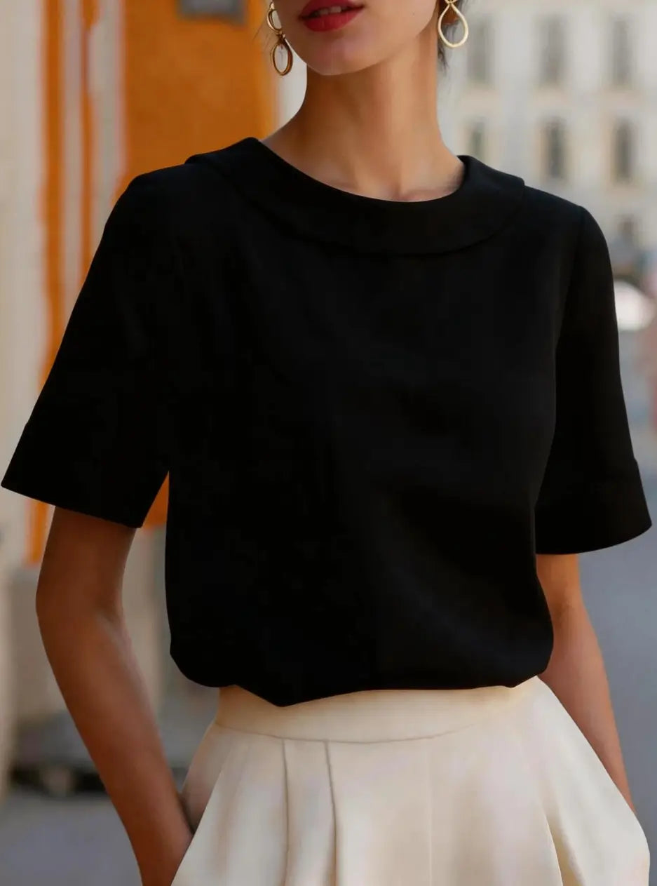 Black short-sleeved women solid color versatile top with rounded neckline and soft flowing fabric.