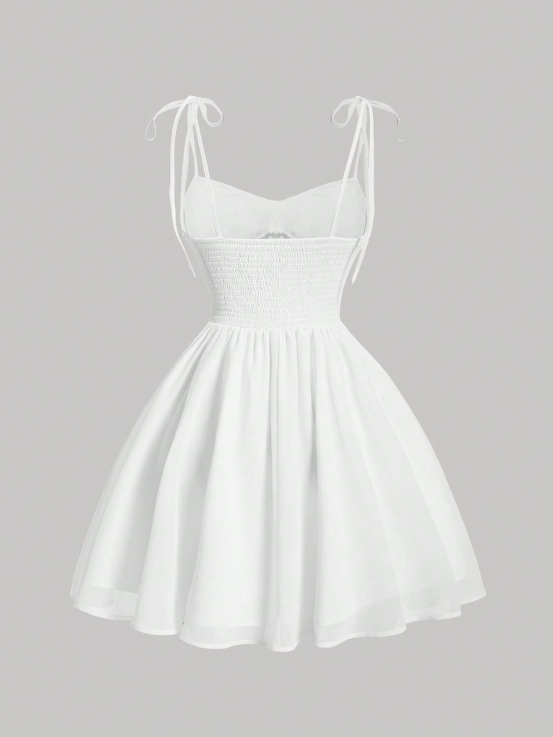 White smocked mini dress with adjustable tie straps and a flared skirt featuring a ruched corset design.