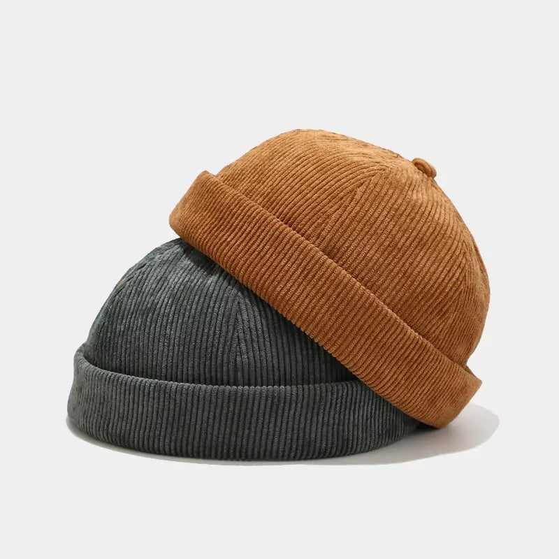 A cozy ribbed corduroy landlord beanie adjustable streetwear hat in warm tan and muted gray.