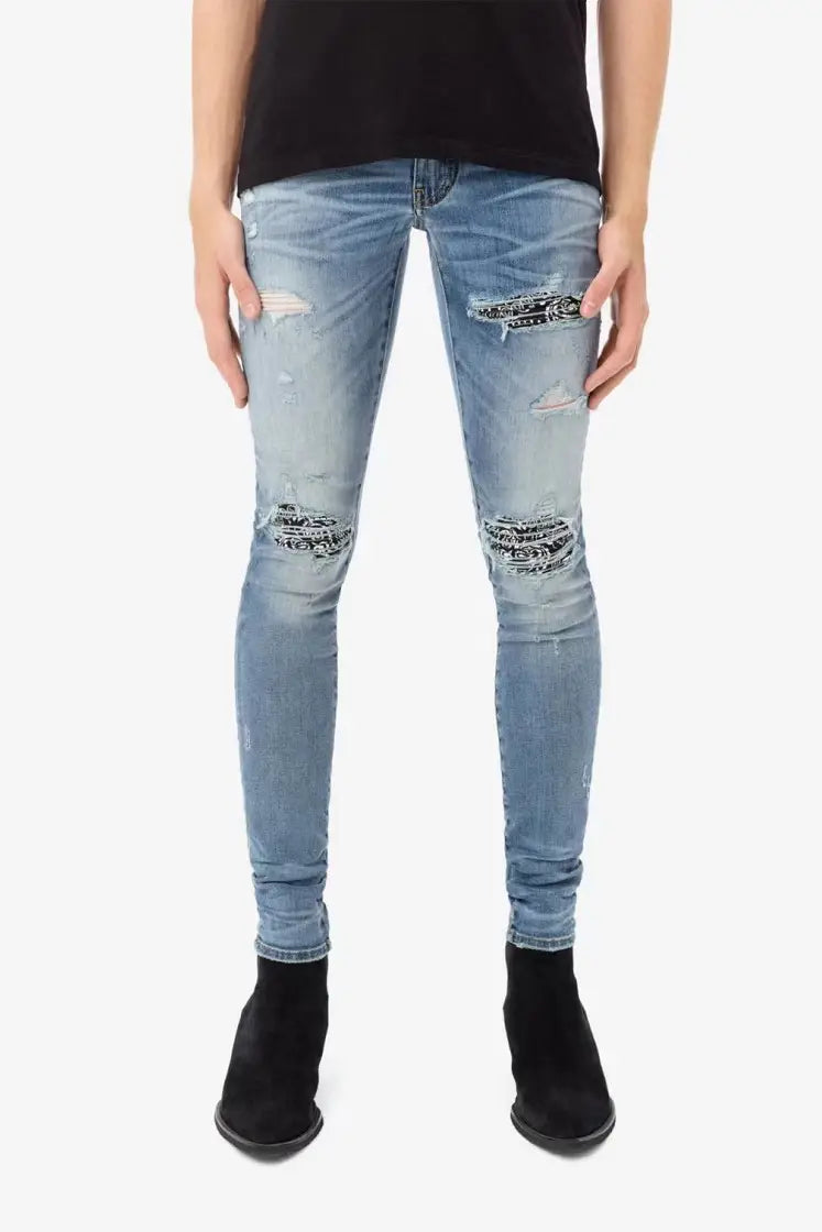 men’s slim fit light wash denim jeans with distressed ripped knees and black bandana-style patches