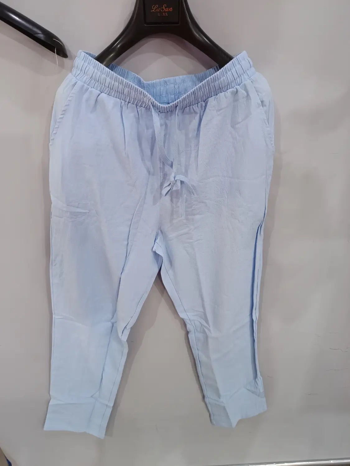 Men’s light blue linen joggers made of soft cotton with an elastic waistband and drawstring for casual wear.