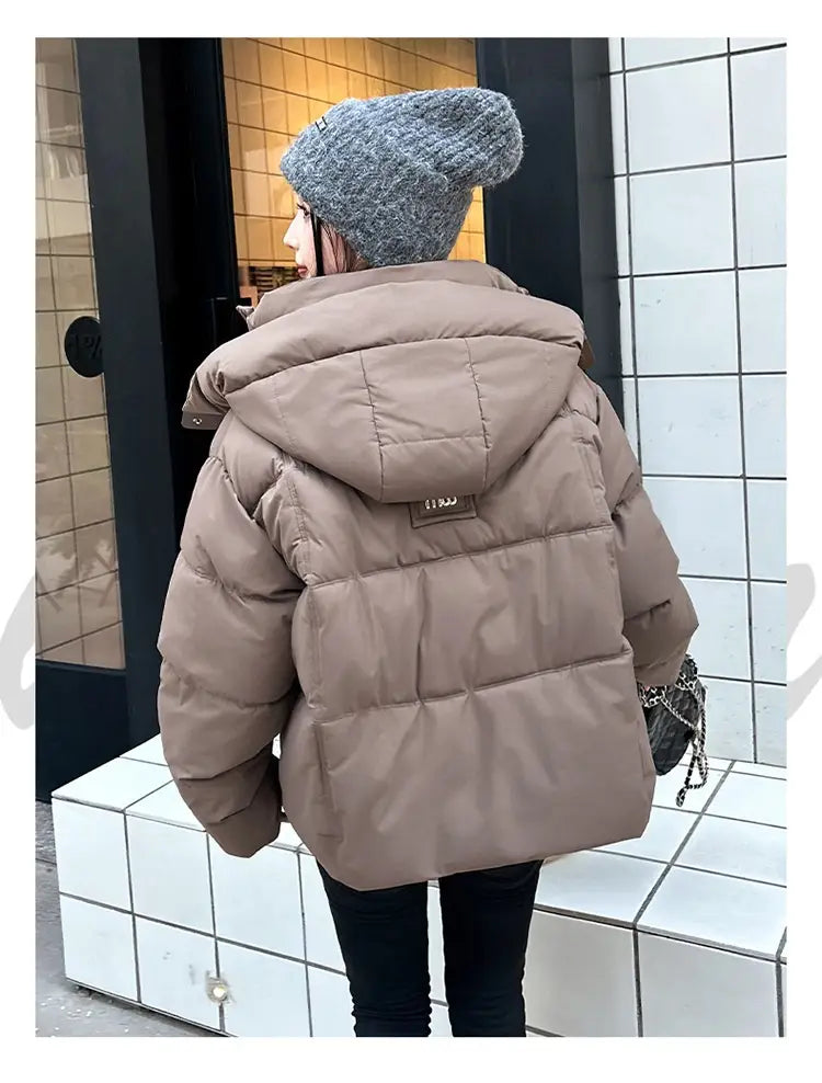 Veste courte matelassée à capuche pour femme beige, conçue pour un hiver chaud, avec design matelassé.