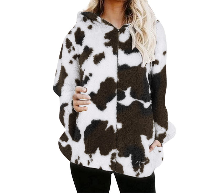 Una chaqueta acolchada con capucha y tipo zip-up acogedora con un patrón de vaca negro y blanco.