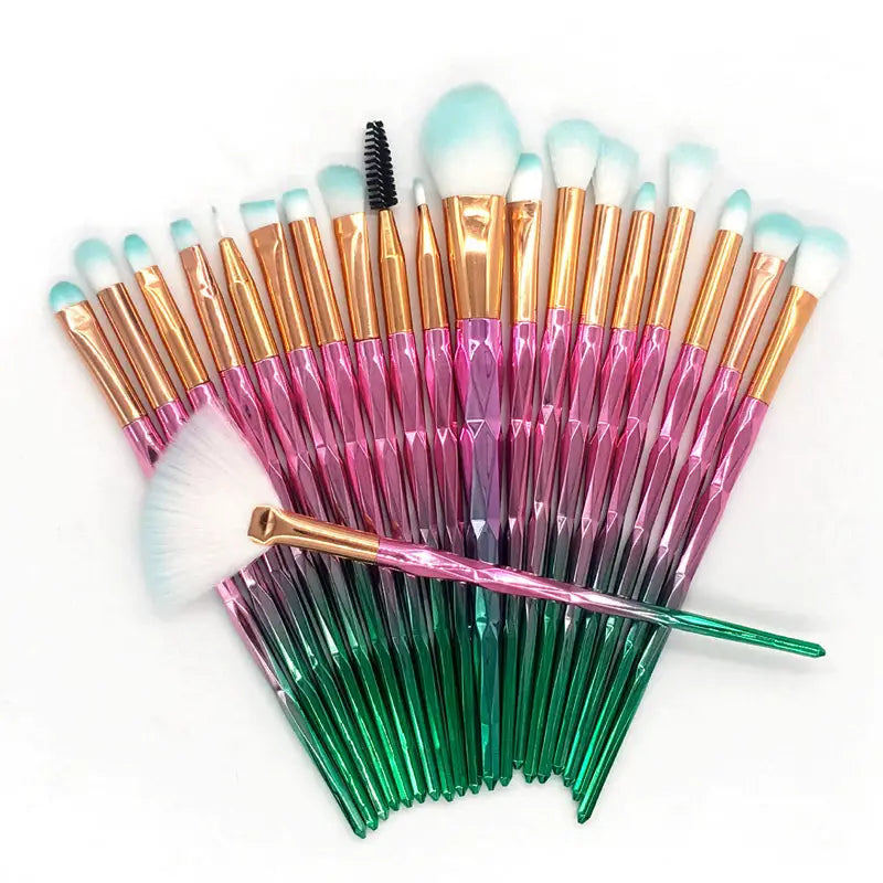 A set of 24 makeup brushes with gradient pink to green translucent handles, rose gold ferrules, and light blue tipped bristles from the makeup brush set 20 piece rose gold and glitter collection.