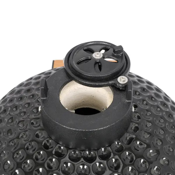 Black ceramic 13 inch kamado charcoal grill with a textured pebbled surface and a circular vent cover featuring a star-shaped design.