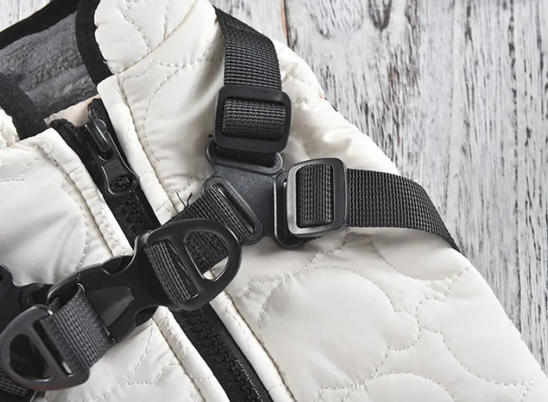 White quilted dog vest with black adjustable straps and plastic buckles designed as a windproof warm pet coat.
