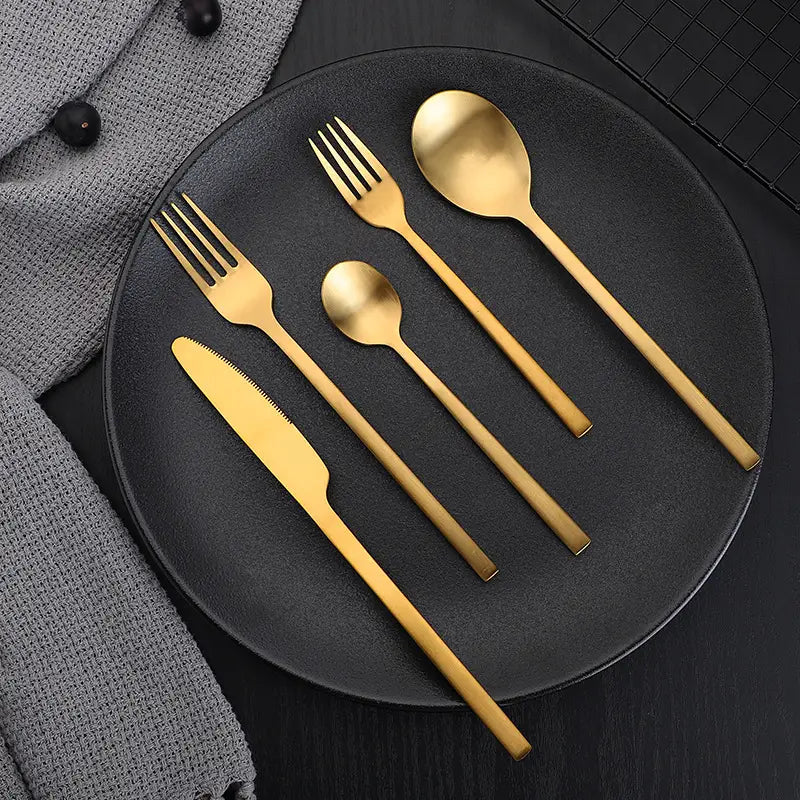 Ensemble de couverts en acier inoxydable doré, au design moderne et épuré, avec une finition mate de couleur dorée